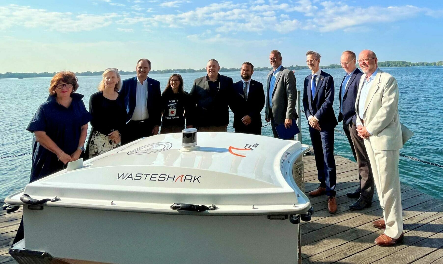 Group of dignitaries standing behind the PortsToronto WasteShark drone