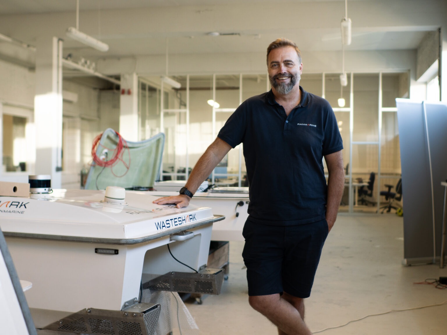 Richard Hardiman standing in a workshop with WasteShark in production
